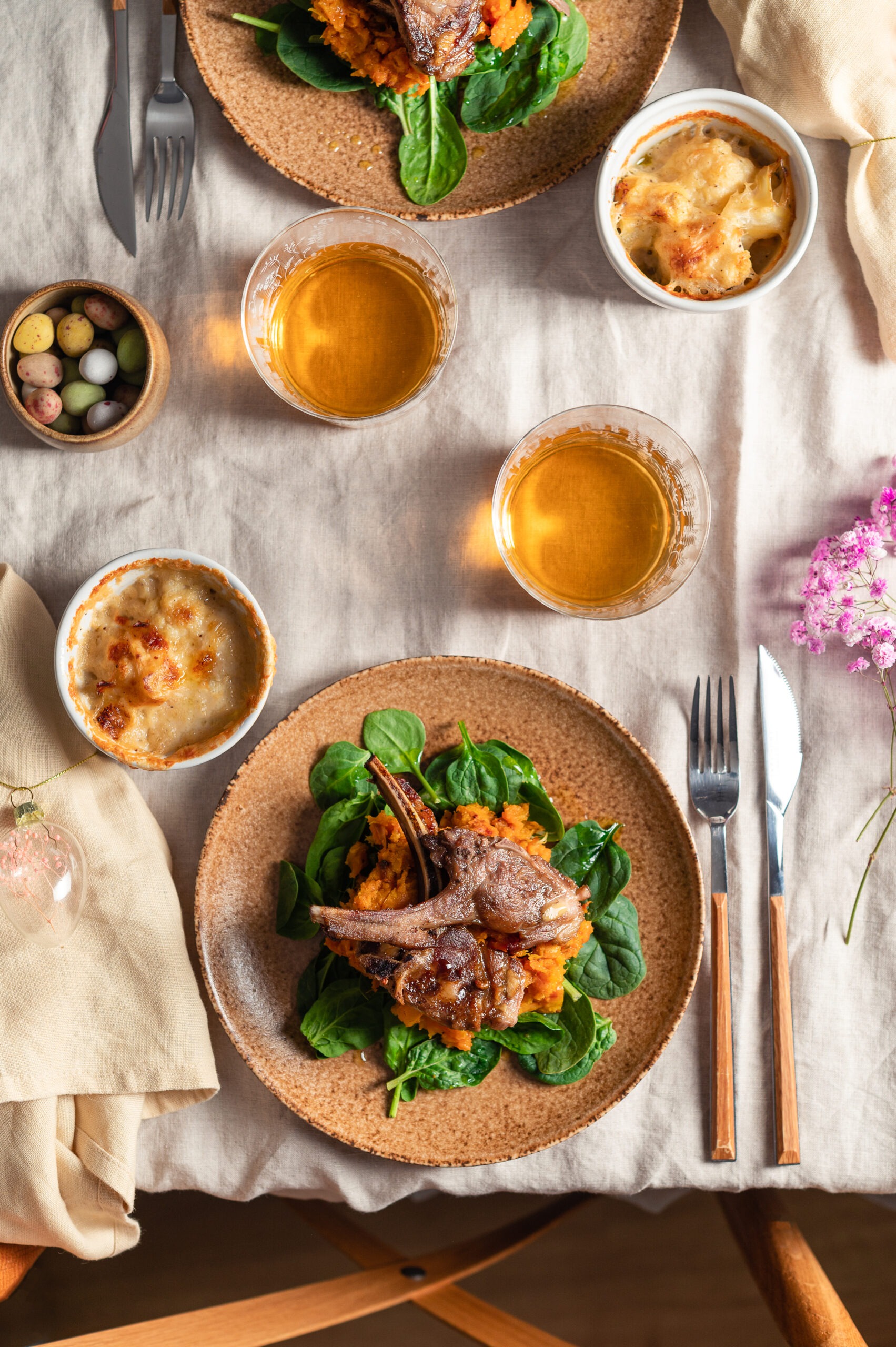 Borrego assado sobre cama de espinafres e esmagada de batata doce com couve flor gratinada